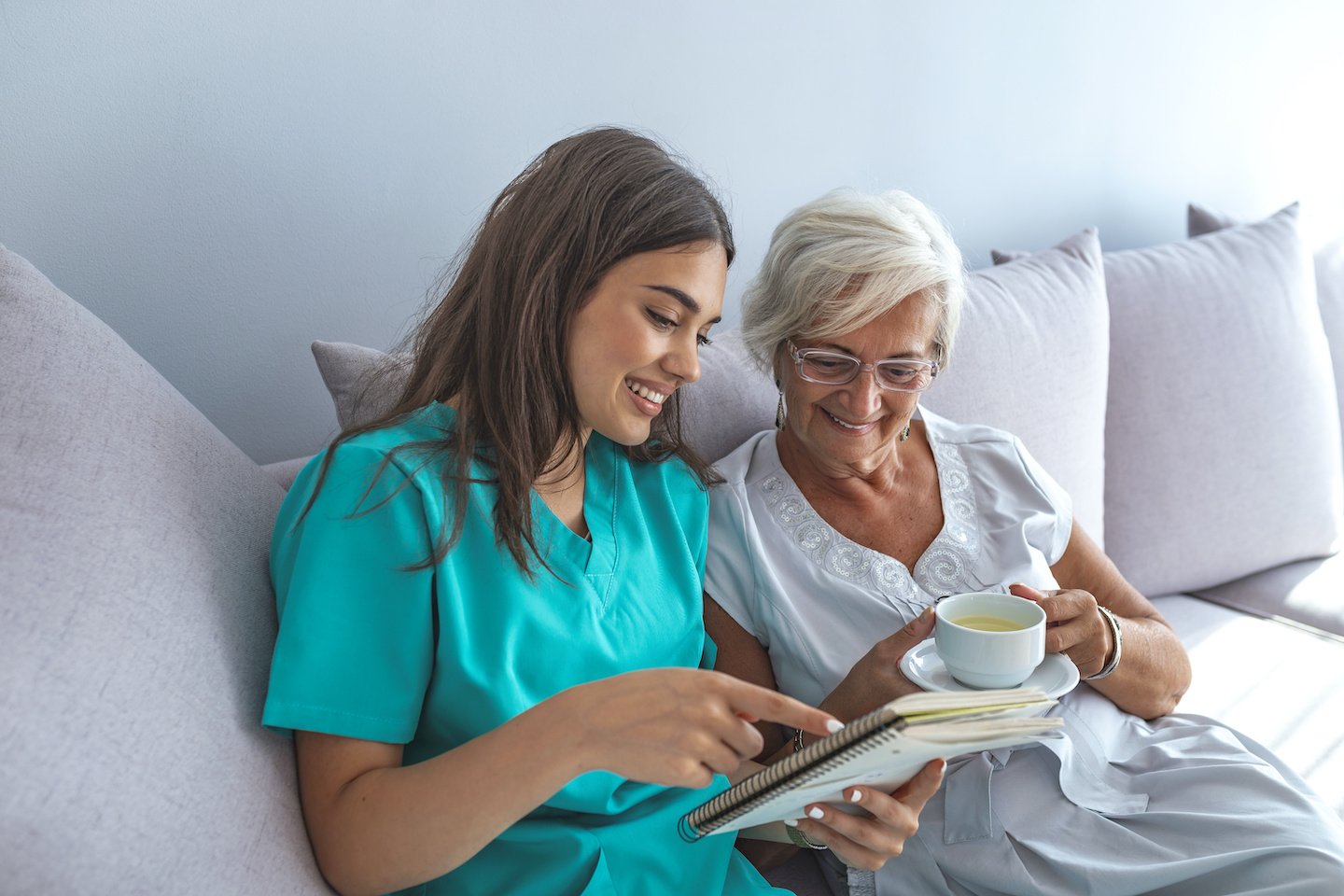 Close positive relationship between senior patient and caregiver. Happy senior woman talking to a friendly caregiver. Young pretty caregiver and older happy woman