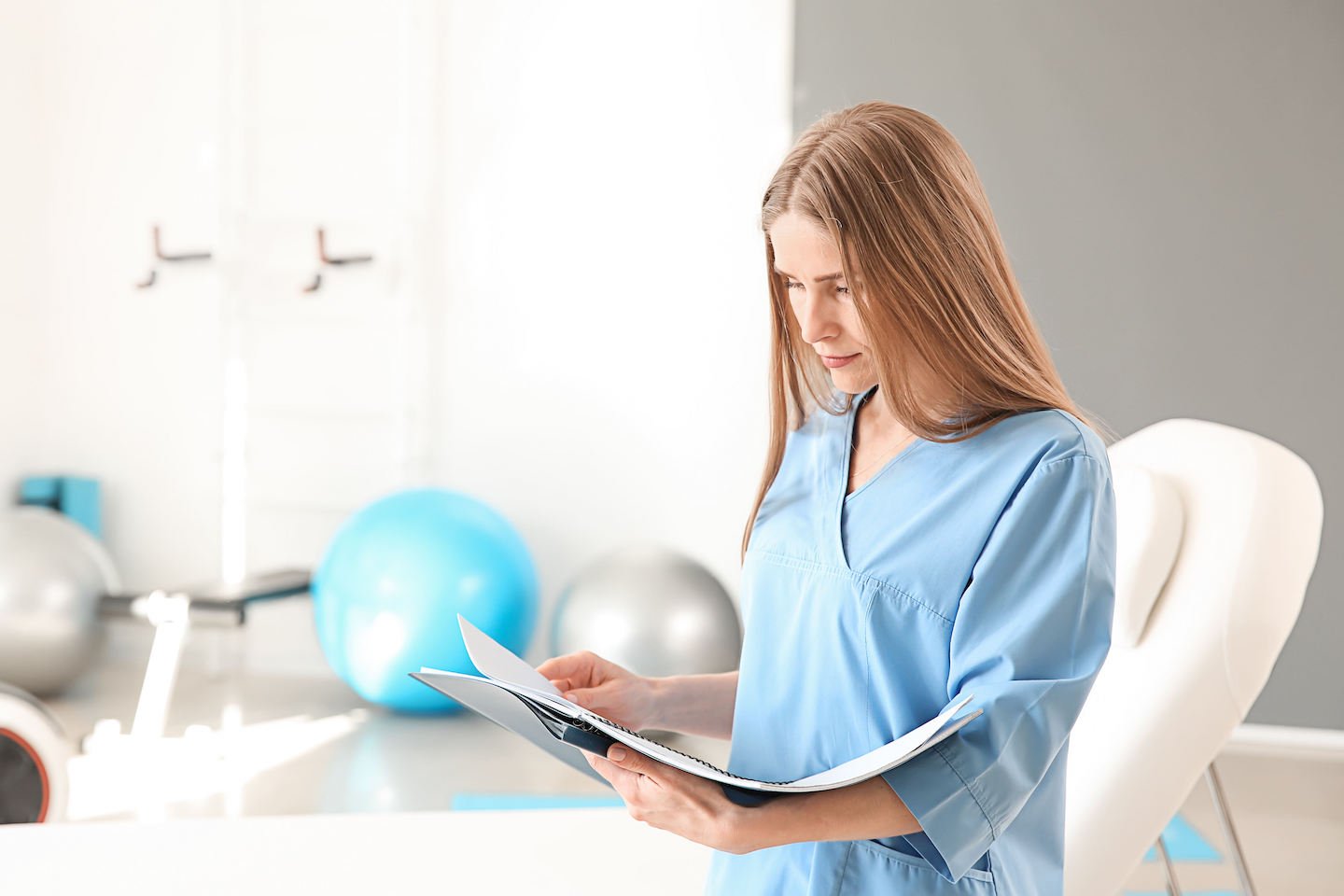 Female physiotherapist in rehabilitation center reviewing medical files