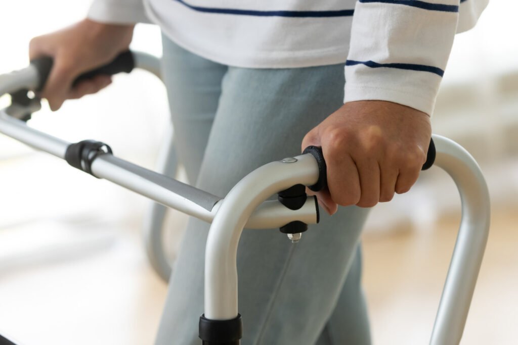 Disabled injured senior woman standing alone holding walking frame at home hospital, old elderly handicapped grandma using walker, older people physiotherapy rehabilitation concept, close up view